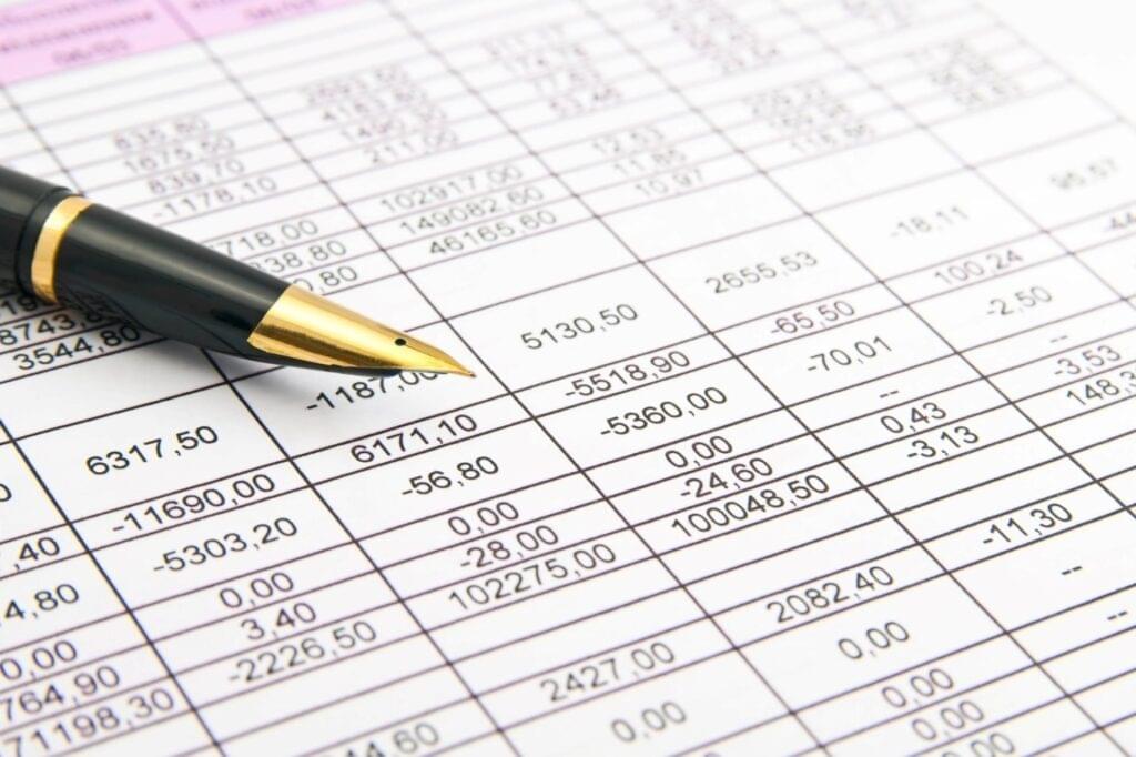 Financial spreadsheet with a pen, showcasing top restruct experts analyzing restructuring opportunities for home loans.